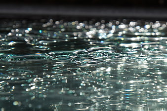 Close-up of shimmering water surface with bokeh reflections