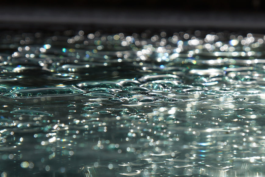 Close-up of shimmering water surface with bokeh reflections