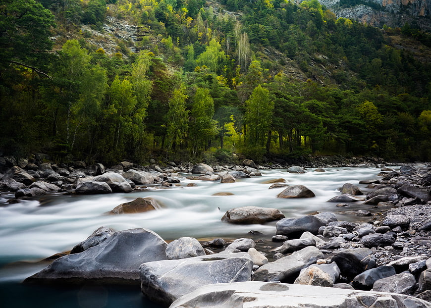 Serene Mountain Stream Flowing Over Rocks in Forest
