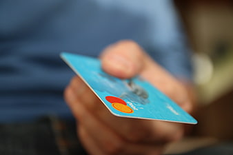 Hand Holding Blue Credit Card with Mastercard Logo