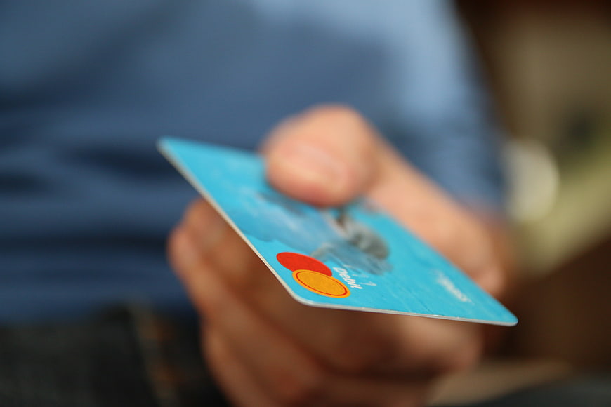 Hand Holding Blue Credit Card with Mastercard Logo