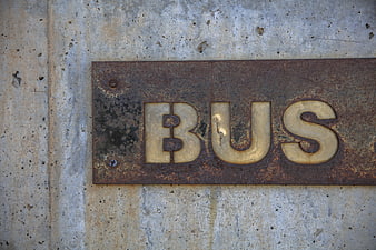 Rusty Metal Bus Sign on Concrete Wall