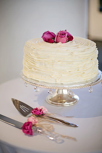 Elegant white ruffle wedding cake with pink roses