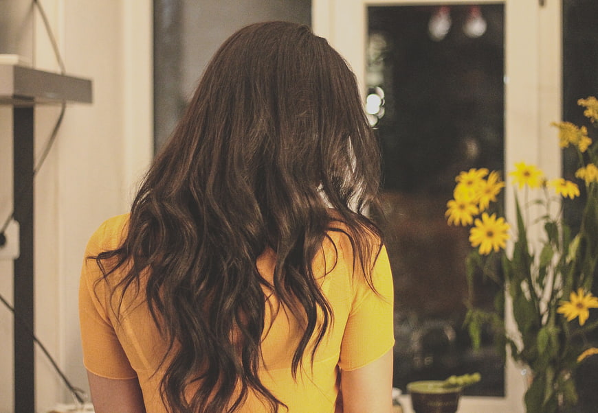 Woman with Long Wavy Hair Looking Out Window