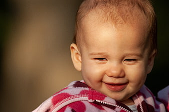 Close-up Portrait of a Smiling Baby in Pink Jacket