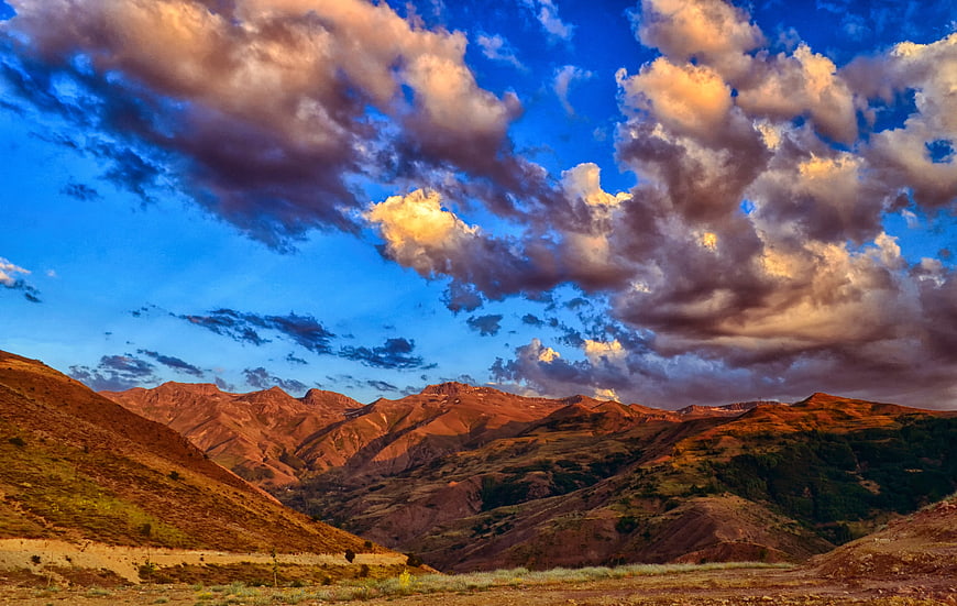 Dramatic Sunset Over Rugged Mountain Landscape with Clouds