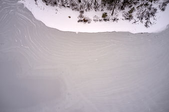 Aerial view of frozen lake with snow and trees