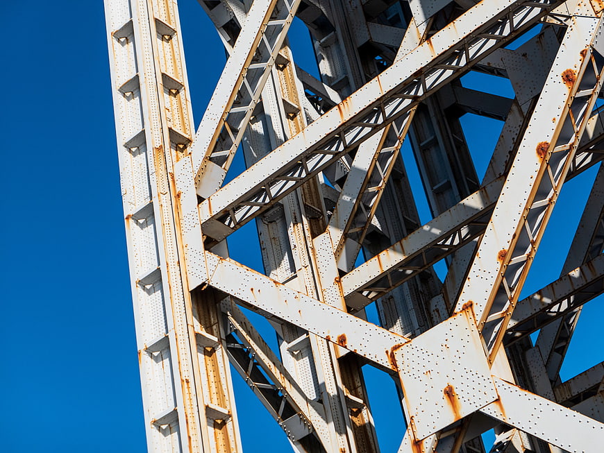 White Steel Bridge Truss Structure Against Blue Sky