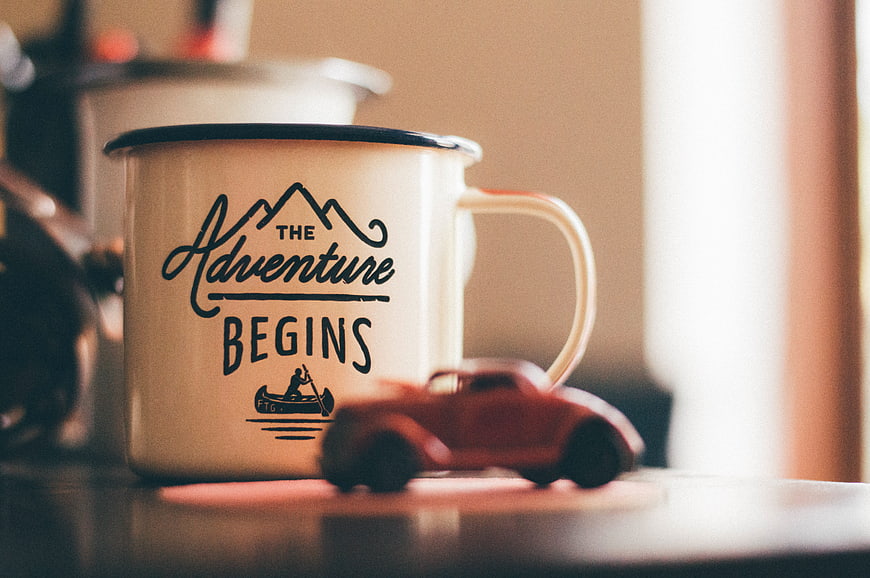 Enamel mug with adventure quote and toy car