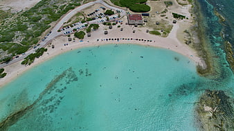 Aerial View of Turquoise Beach with Parking Lot and Swimmers