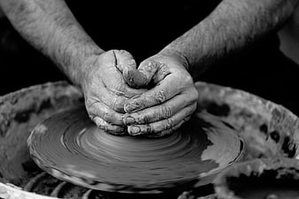 Close-up of hands shaping clay on a pottery wheel
