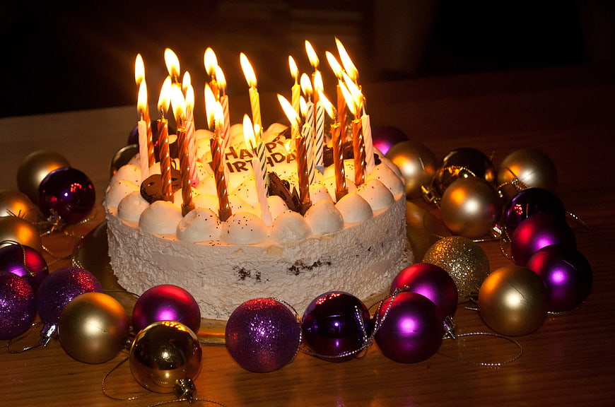 Birthday Cake with Lit Candles and Christmas Ornaments
