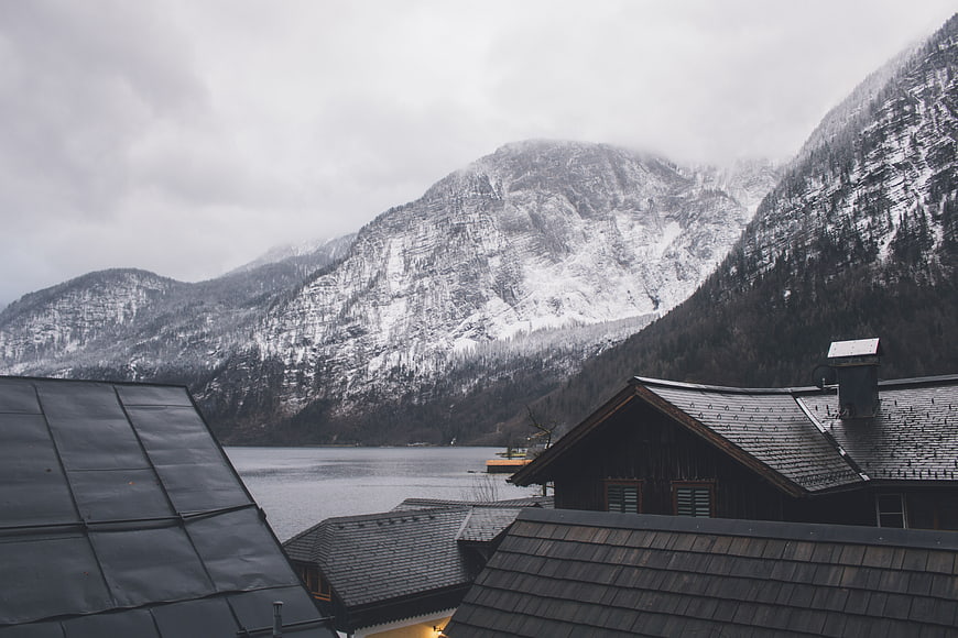 Snowy mountain landscape with lake and wooden chalet roofs