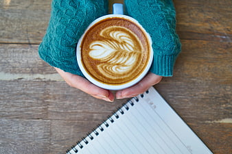 Top View of Hands Holding Latte Art Coffee Cup