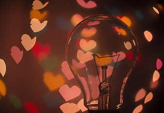 Light bulb with colorful heart bokeh background