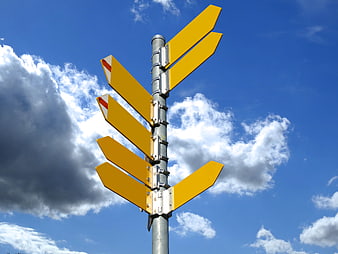 Yellow Directional Signpost Arrows Against Blue Sky And Clouds