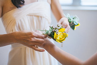 Bridesmaid Pinning Yellow Corsage on Bride's Wrist