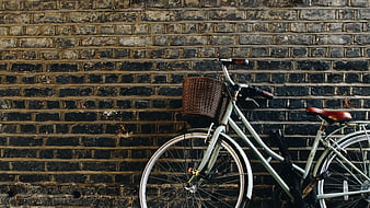 Vintage bicycle with basket against dark brick wall