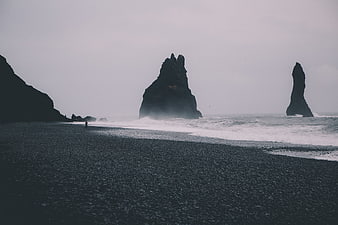 Dramatic black sand beach with sea stacks and crashing waves