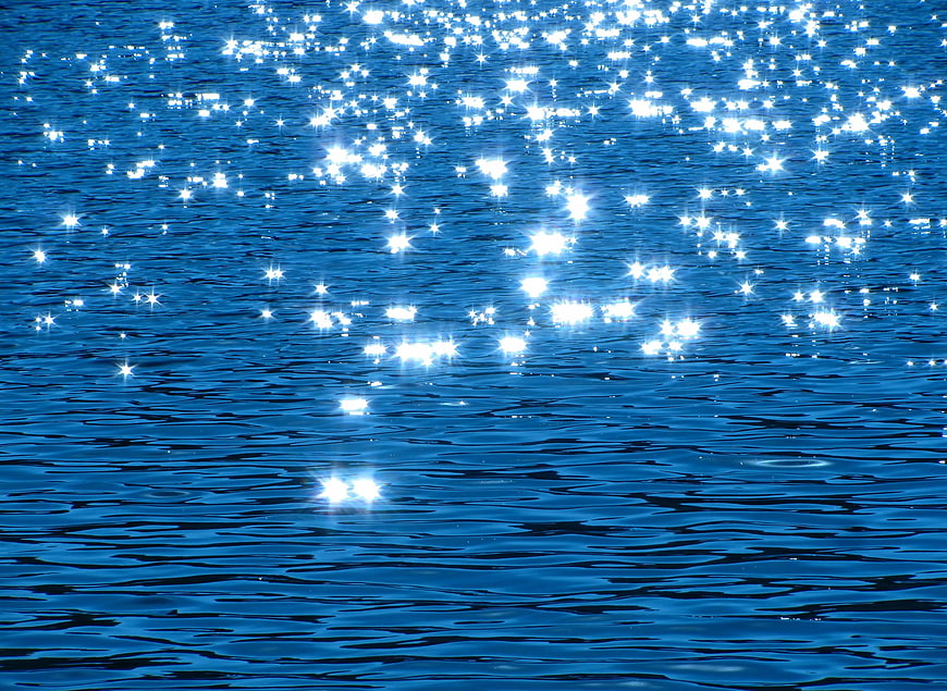 Sparkling Sunlight Reflections on Deep Blue Water Surface
