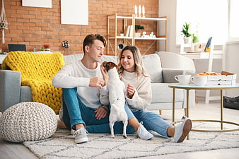 Happy young couple relaxing at home with dog and pizza