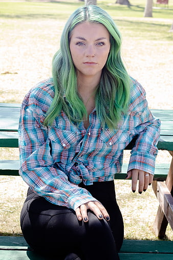Young Woman with Green Hair Sitting on Park Bench