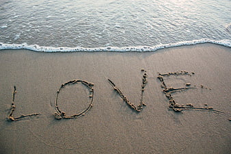 Word Love Written in Sand on Beach Shore