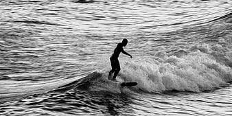Silhouette of Surfer Riding Wave in Black and White