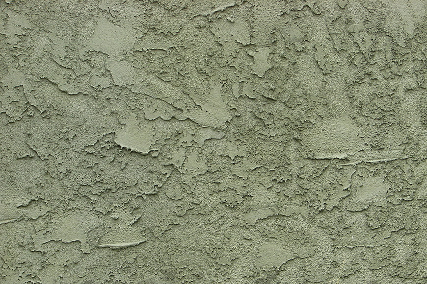Greenish stucco wall texture with uneven plaster surface