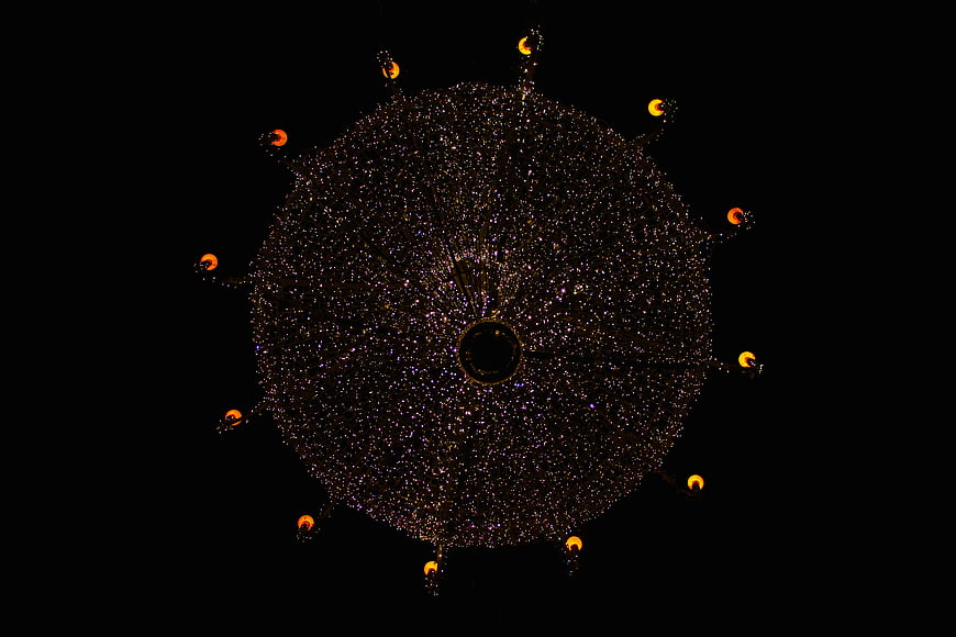 Large circular Christmas light display with starburst pattern at night