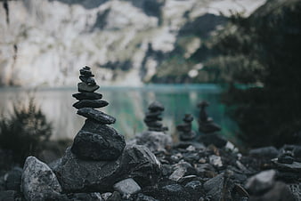 Stacked stones by a serene mountain lake