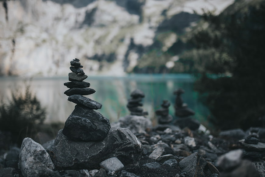 Stacked stones by a serene mountain lake