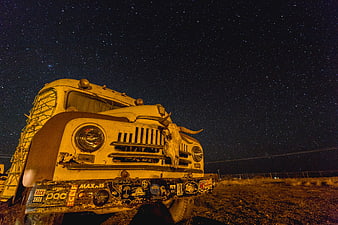 Vintage truck with bull skull under starry night sky
