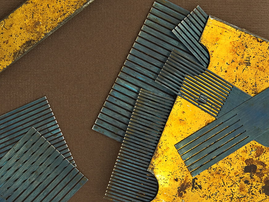 Rusty metal combs on textured yellow and brown background