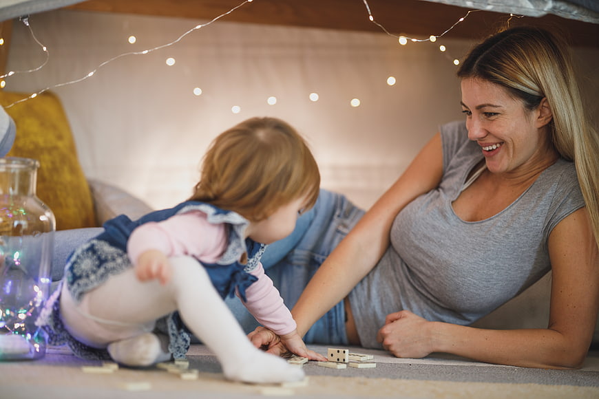 Mother and Toddler Playing Dominoes in Cozy Fort