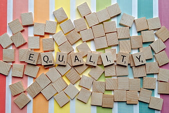 Scrabble Tiles Spelling Equality on Rainbow Striped Background