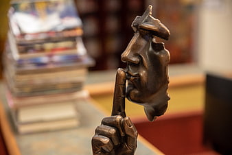 Bronze Shushing Hand Sculpture In Library Setting