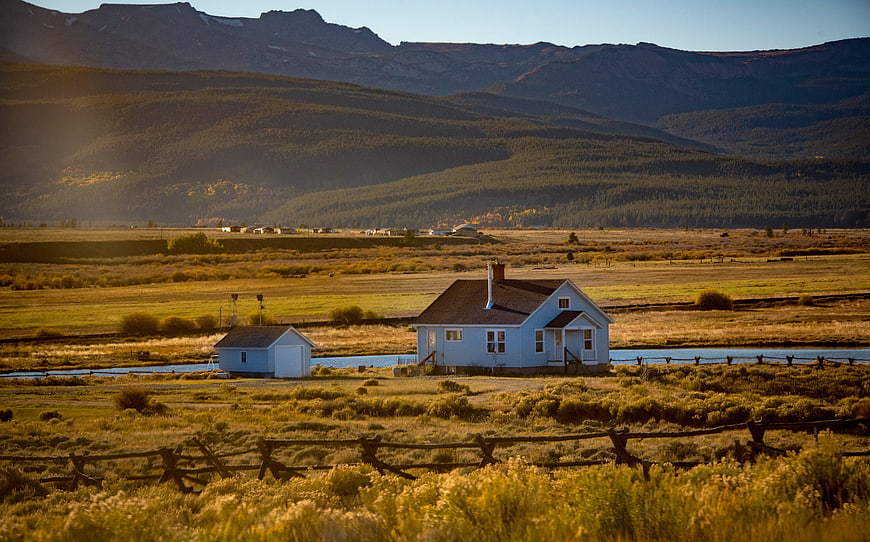 Rustic Blue House in Golden Mountain Valley Landscape