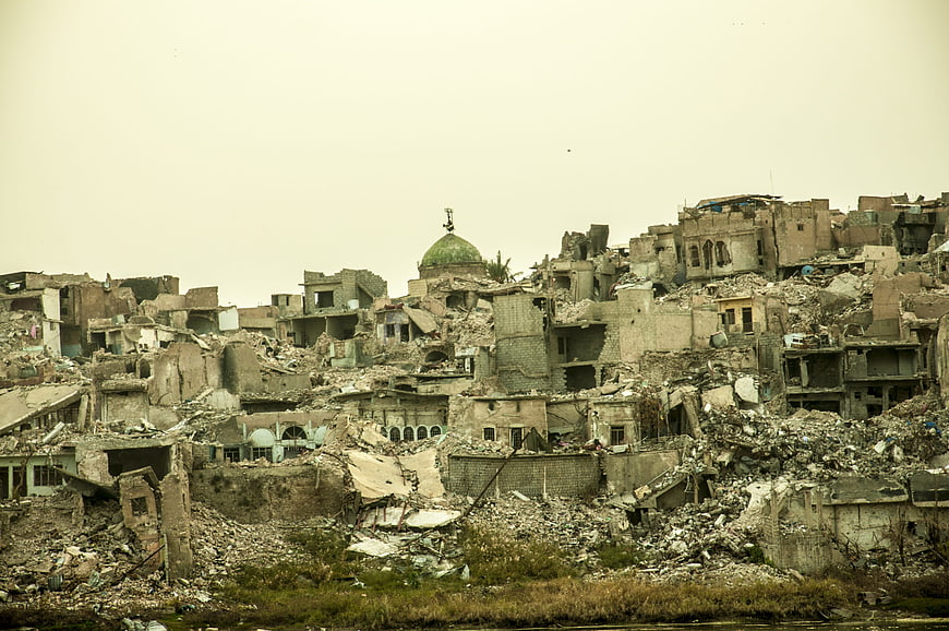 War-torn cityscape with destroyed buildings and a green dome