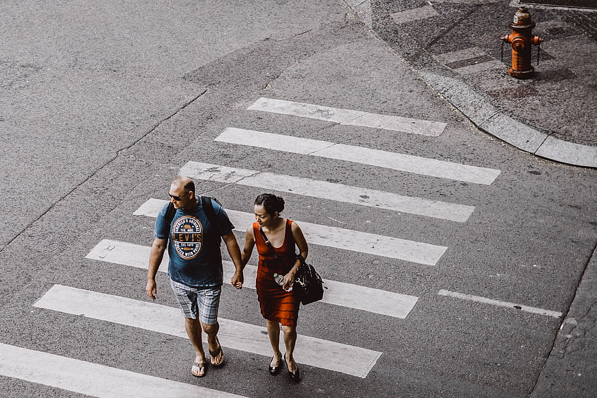 High angle view of couple holding hands crossing street