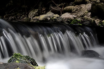 Long Exposure Small Waterfall Flowing Over Mossy Rocks