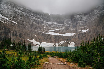 Misty Mountain Lake with Snowy Cliffs and Forest Trail