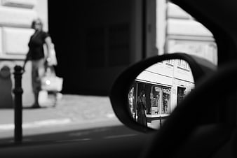Black and white street scene with car side mirror reflection