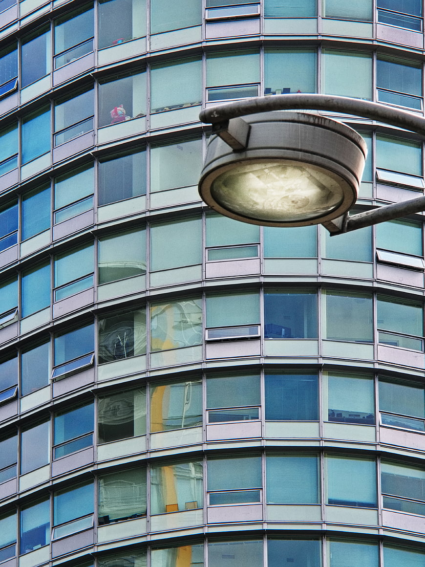 Modern glass office building facade with street lamp
