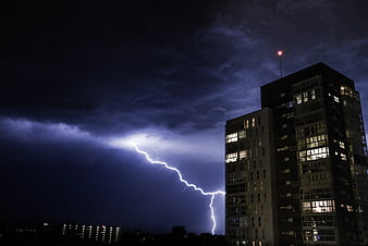 Dramatic Lightning Strike Near Modern Apartment Building at Night