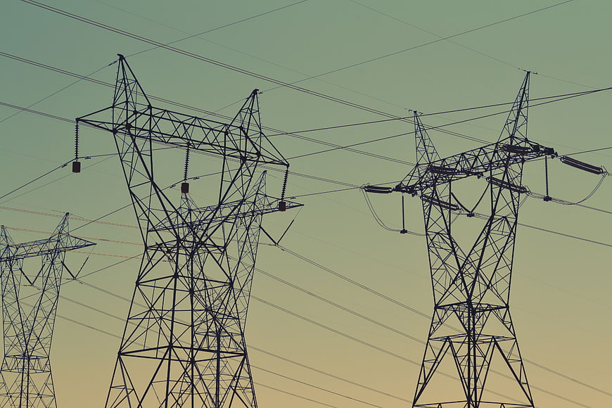 Silhouetted High Voltage Power Lines Against Gradient Sky