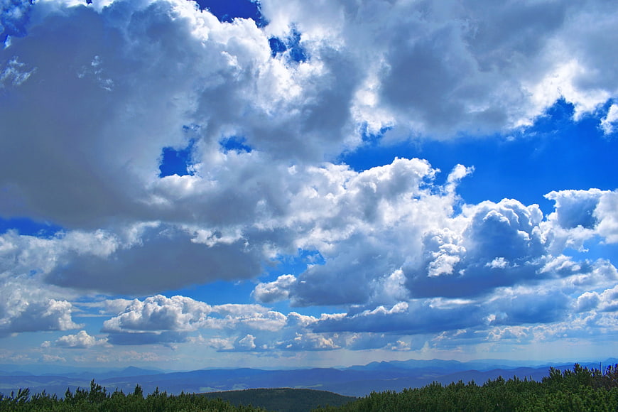 Dramatic blue sky with clouds over mountain landscape
