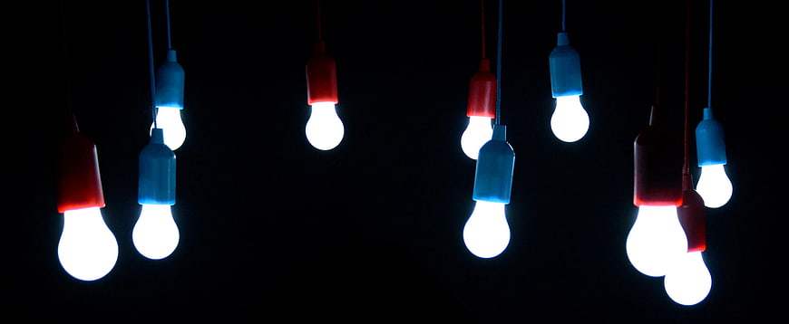 Colorful Hanging Light Bulbs Against Black Background