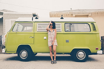Woman in Floral Dress Leaning on Vintage Green VW Bus