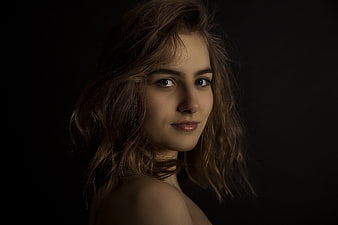 Dramatic Dark Studio Portrait of Young Woman with Wavy Hair